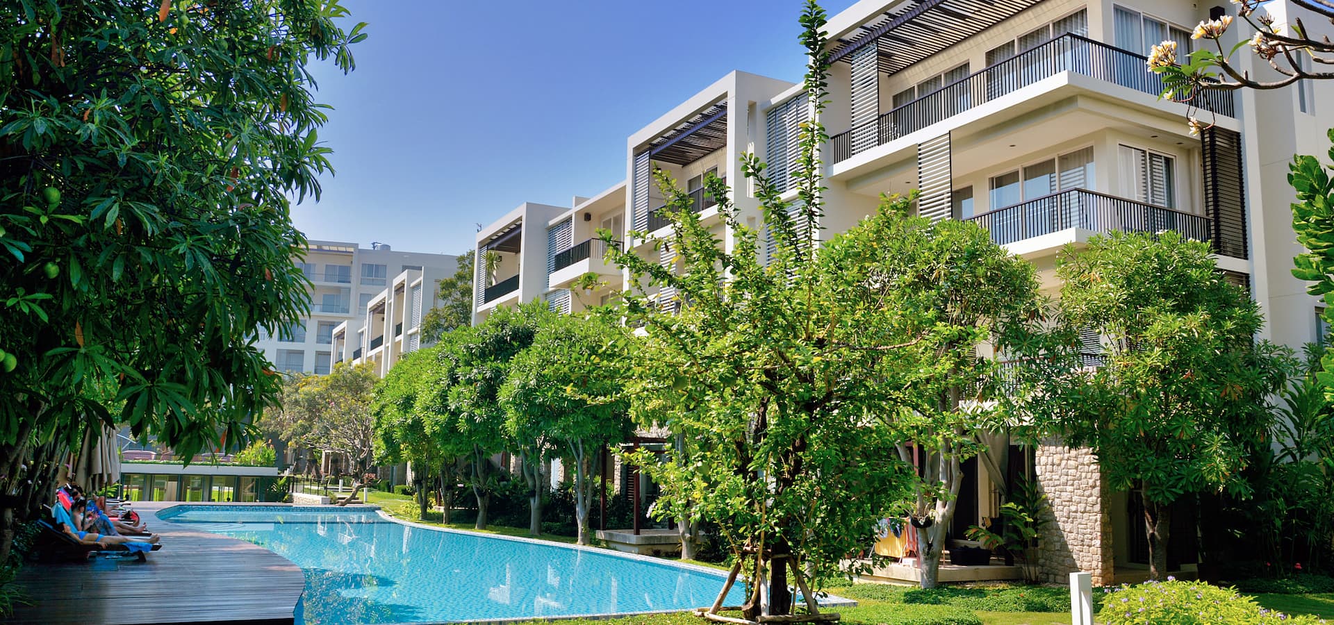 A low-rise branded residence development in Phuket arranged around a shared pool and amenity deck