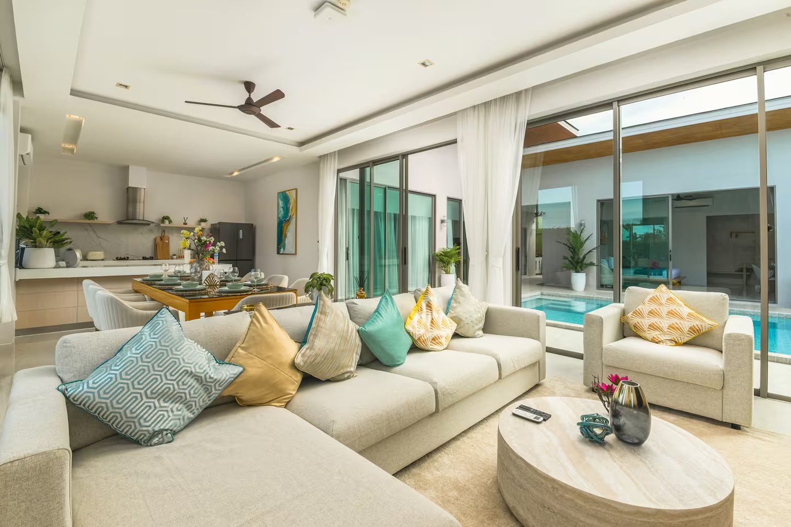 The open-plan living room of Villa Mimosa 4, looking through sliding doors to the pool terrace