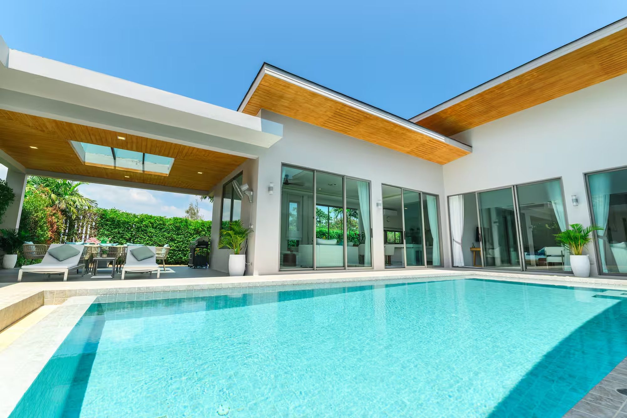 The pool and covered terrace of Villa Mimosa 4 in Rawai, Phuket, photographed in full sun
